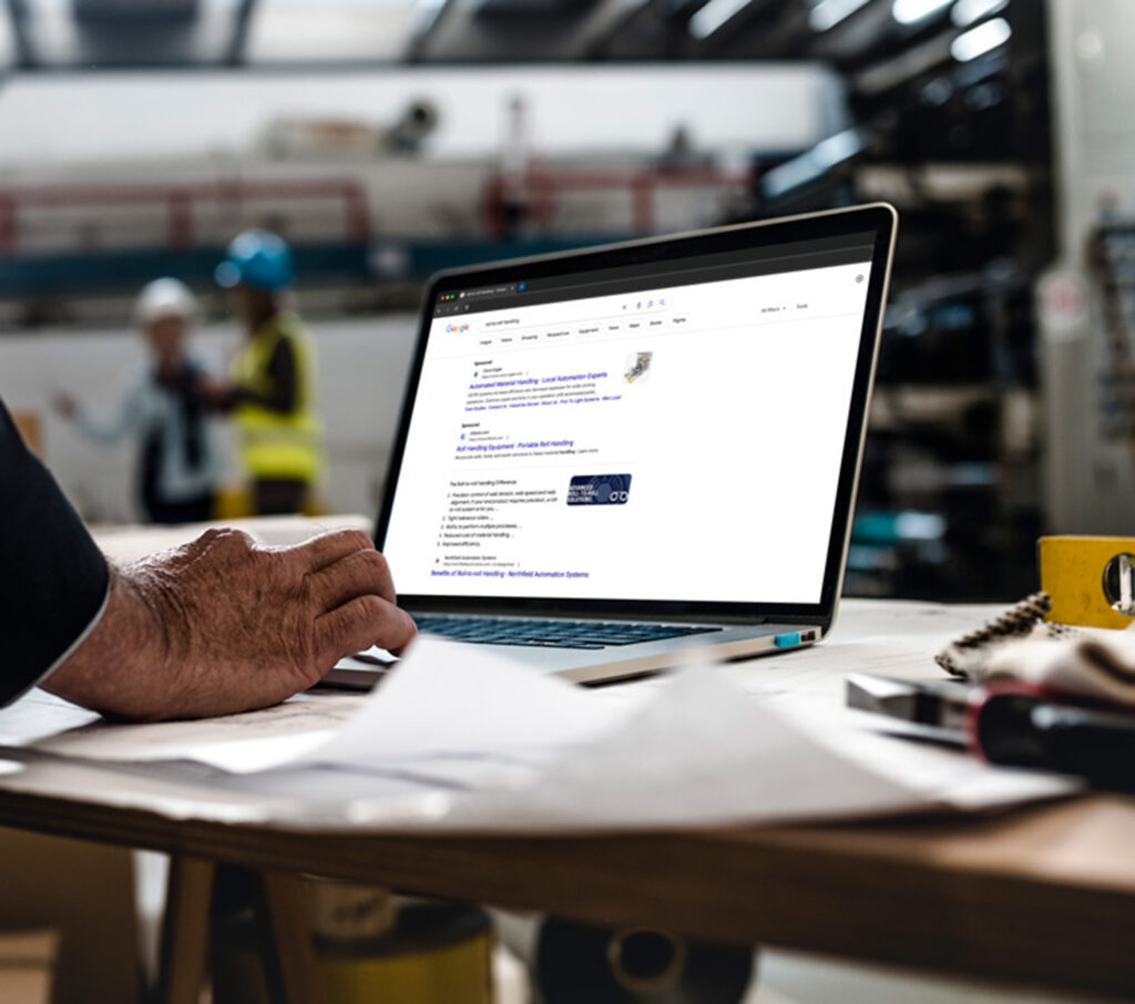 Worker researching on a laptop in a manufacturing facility